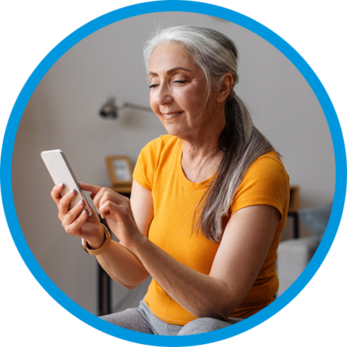 A woman in exercise clothes sitting at home and using her smartphone